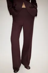 Blazer entallado color bordó con hombreras, solapas clásicas, bolsillos delanteros con solapa y cierre frontal de un botón.