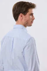 Camisa de manga larga con estampa de cuadros pequeños en tonos celeste y blanco, cuello con botones y bolsillo ojal en el pecho con detalle bordado.