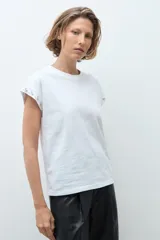 Remera de algodón color blanco, de corte clásico y manga corta, con detalle de strass en el borde de la manga.