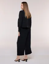 Camperita liviana de corte recto y acabado crepé color blanco, con cuello camisero clásico y cierre frontal de botones metálicos dorados. Presenta bolsillos en el pecho con solapa y mangas largas con puños abotonados.