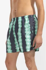 Short de baño negro con estampado de flores verdes y celestes, cintura elástica con cordón regulable, bolsillos laterales y trasero con cierre, suspensor de malla fina hipoalergénico.