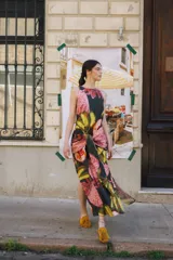 Vestido midi de popelina con cuello redondo, diseño sin mangas de corte semi-halter y lazos frontales para atar a la cintura. Estampado multicolor con motivos de mangos y flores.