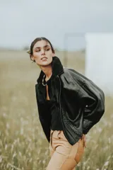 Campera oversize de cuero tostado con solapas y forro interno de corderito sintético azul marino, mangas anchas y detalles de costuras trenzadas.