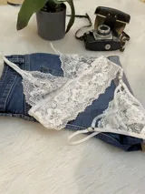 Conjunto de lencería compuesto por un top bralette de encaje floral con breteles regulables y una tanga colaless a juego con tiras laterales ajustables.