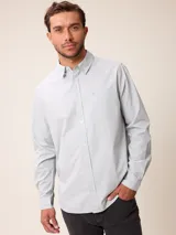 Camisa de manga larga en color blanco, confeccionada en algodón. Presenta cuello abotonado, cierre frontal con botones y un bolsillo en el pecho.