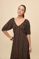 Vestido largo celeste con estampado botánico en tonos marrones, escote en V, mangas cortas abullonadas y falda con volado en el bajo.
