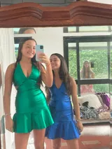 Vestido corto negro con estampado de plumas doradas, escote en V, breteles finos cruzados en la espalda, cut-outs laterales y volado en el ruedo.