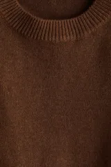 Buzo de punto fino con hombreras, cuello redondo y diseño de corte recto. Presenta terminaciones acanaladas en cuello, puños y bajo.