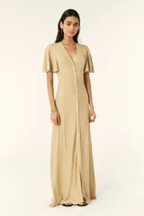 Vestido largo dorado de punto con mangas cortas con volantes, escote en V y cierre frontal con botones.