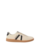 Championes de diseño urbano, color beige con franjas laterales negras y suela de goma marrón.
