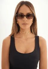 Lentes de sol con armazón ovalado de diseño carey en tonos marrones y cristales oscuros con protección UV400.