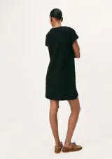 Vestido corto negro de manga corta, con corte recto, escote redondo y un bolsillo aplicado en el pecho.