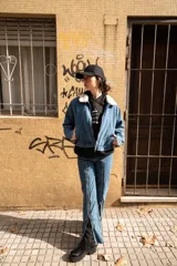 Pantalón de jean azul con cierre metálico en la parte inferior de la pierna.