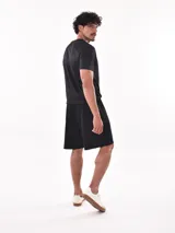 Remera deportiva de manga corta, color gris claro con sutil textura de rayas horizontales. Presenta cuello redondo y costuras reforzadas en los hombros.