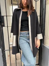 Camisa negra de tejido de punto con detalles en cuero color plata en cuello, solapa, puños y bolsillos.