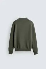 Sweater de punto negro de corte regular fit, confeccionado en algodón con cuello redondo, manga larga y acabados en rib.