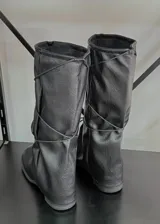 Botas bucaneras de cuero vegano en color negro, con diseño de caña holgada y efecto arrugado. Presentan punta redondeada y suela plana.