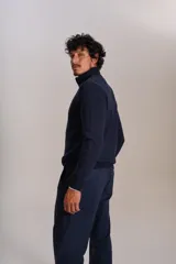 Cardigan de punto color azul marino, con cuello alto, cierre frontal completo y puños acanalados. Presenta el logo de la marca bordado en el pecho.