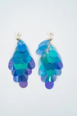 Caravanas colgantes con diseño de escamas en tonos iridiscentes azules, verdes y violetas. Cuentan con cierre de perno y tuerca metálico.