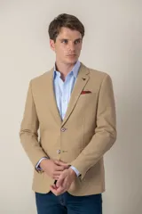 Saco sport color beige de jersey, corte slim fit, con cierre de dos botones, solapa de muesca, bolsillo de parche en el pecho y bolsillos delanteros con solapa.