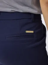 Pantalón de corte recto y tiro medio, confeccionado en gabardina de algodón con un toque de elastano. Presenta cierre frontal con botón y bolsillos laterales.