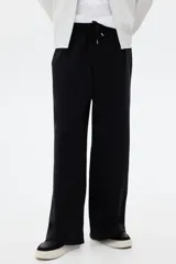 Pantalón de jogging de felpa de algodón pesado, con corte de pierna ancha y silueta relajada. Presenta cintura elástica con cordón ajustable, bolsillos laterales al bies y un bolsillo de parche en la parte trasera.