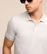 Remera polo Request de corte slim, confeccionada en tejido de media malla con textura acanalada. Presenta cuello inglés con cierre de botones y mangas cortas.