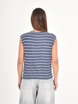 Remera sin mangas de corte holgado, con cuello redondo y diseño de rayas horizontales finas en color negro sobre fondo blanco.