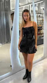 Vestido corto negro de tirantes finos, con escote recto y estampado de pequeños puntos brillantes plateados.