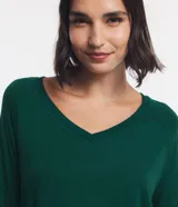 Blusa básica de viscosa verde militar con escote en V, mangas 3/4 y puños anchos en rib. Cuenta con costuras decorativas y dobladillo inferior ancho.
