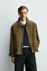 Sobrecamisa relaxed fit de piel con acabado en ante de color verde militar, con cuello solapa, manga larga con puño abotonado, bolsillos de vivo en la cadera y cierre frontal con botones.