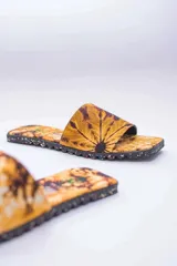 Sandalias de verano con estampado batik en tonos amarillos y marrones, hechas con suela de neumáticos reciclados y capellada de algodón.