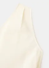 Top asimétrico color blanco marfil de lyocell, con un solo hombro descubierto y detalle de lazo lateral.