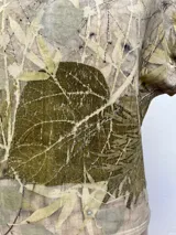 Vestido largo con estampado de hojas en tonos verdes y marrones.