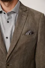 Blazer de corte slim fit confeccionado en pana de textura suave, con cierre frontal de dos botones, solapas clásicas y bolsillos laterales con solapa.