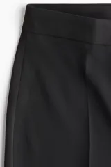 Pantalón sastrero de tiro alto y piernas amplias con pliegues en la parte delantera y trasera, en color negro.