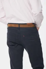 Pantalón de vestir azul marino, de corte recto, con bolsillos laterales y traseros. Se ajusta a la cintura con cinturón de cuero marrón.
