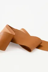 Cinturón faja de cuero ovino color suela, con diseño de hebilla en forma de corazón y detalle de tachas metálicas en todo el contorno.