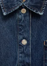 Chaqueta vaquera azul con cuello camisero, cierre frontal con botones metálicos, tres bolsillos delanteros, mangas largas con puños abotonados y cinturón de lazo.