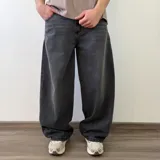 Pantalón jean de corte barrel, color azul clásico con efecto desgastado y diseño amplio y curvado en las piernas.