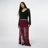 Falda larga de encaje color bordó, con forro corto y abertura frontal.