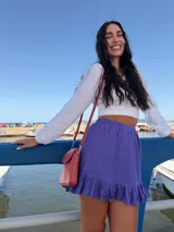 Bandolera pequeña tipo porta celular, color verde claro, confeccionada en cuero sintético. Cuenta con cierre principal, bolsillo frontal con tapa y broche a presión, y correa ajustable extraíble.