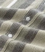 Camisa de hombre de manga corta con cuello tradicional y abotonado frontal. Presenta un tejido texturizado con un patrón de rayas verticales en tonos beige, blanco y marrón claro.