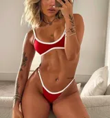 Conjunto de bikini rojo con ribetes blancos, compuesto por un corpiño triangular con tirantes finos y una bombacha tipo tanga.