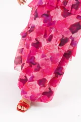 Vestido largo fucsia con estampado abstracto, cuello halter con abertura en forma de lágrima y volados en la falda.