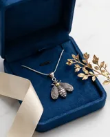Dije con forma de abeja elaborado en plata 925 con detalles en lámina de oro 18k. Presenta un diseño detallado en las alas y cuerpo con acabado envejecido.
