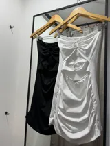 Minivestido ajustado con escote strapless y aberturas en el abdomen unidas por aros.