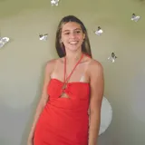 Vestido corto color coral, con escote halter, corte debajo del busto y espalda descubierta.