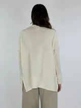 Sweater gris de manga larga con cuello redondo y puños con detalle de volados de lana rizada.