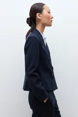 Blazer de corte recto y diseño cropped, con doble botonadura frontal, solapas clásicas y estampado de rayas diplomáticas.